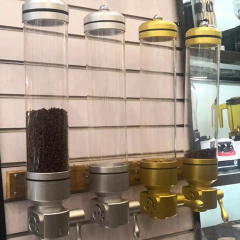 Wall Mounted Coffee Bean Dispenser With Clear Acrylic Shell And Tight Screw Lid To Keep The Stash Fresh, silver and gold, filled with beans.