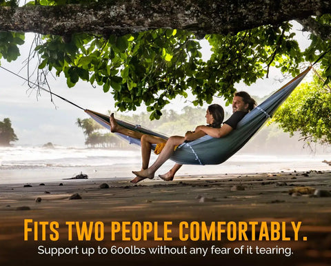 Couple lounging in Cozy Two Person Camping Hammock With Bug Net And Rain Fly Lightweight Double Parachute Nylon Holds 600 Lbs.