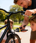 Man using Beefy 7-1/2 Inch Heavy Duty Wire Rope Cutter with Chrome Vanadium Steel Jaw to fix a bicycle outdoors with children watching.