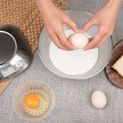 Person cracking egg into removable bowl of Removable Bowl Kitchen Scale 2.5L Capacity 12 lb 5.5 kg Stainless Steel Food Scale For Cookin And Bakin With Backlit Display Ambient Temperature Sensor Alarm Timer Batteries Included