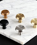 10 Pack Champagne Bronze Cabinet Knobs, 1.4 Inch Round Cabinet Pulls, zinc alloy handles displayed on marble surface