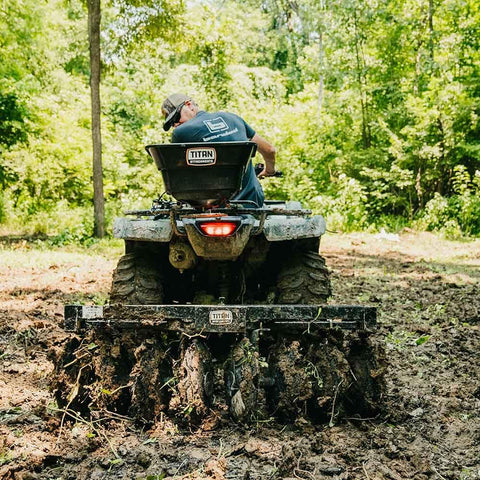 Tow Behind Notched Disc Harrow Attachment for ATV UTV 4 Ft Wide With 2 In Towball Hitch 14 In Concave Discs in use on muddy trail