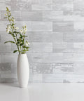 Easy Peel And Stick Three Inch By Six Inch White Birch Subway Backsplash Tiles Set Of One Hundred Pieces Covers Over Twelve Square Feet Ideal For Kitchen Bathroom Laundry Camper And Fireplace Realistic Textured Pvc That Is Scratch Resistant And Colorfast behind a white vase with flowers.