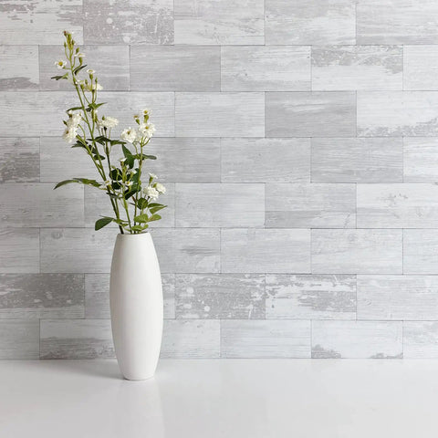 Easy Peel And Stick Three Inch By Six Inch White Birch Subway Backsplash Tiles Set Of One Hundred Pieces Covers Over Twelve Square Feet Ideal For Kitchen Bathroom Laundry Camper And Fireplace Realistic Textured Pvc That Is Scratch Resistant And Colorfast behind a white vase with flowers.