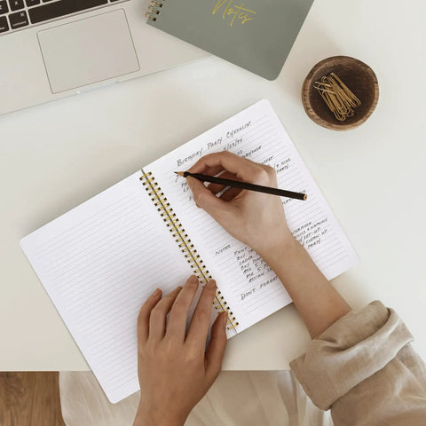 Person writing in Stylish Aesthetic Spiral Notebook Set Of 3 For Women with Cute College Ruled 8x6 Journals on a desk.