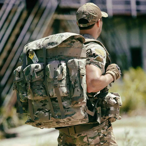 Person outdoors with Beefed Up Military Alice Pack Rucksack Backpack For Survival 50 Liter Tactical Gear With 1000D Waterproof Oxford Fabric