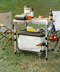 Adjustable Camping Table Folding Lightweight 5Lb Table With Four Height Levels 10 14 19.4 And 23.4 Inches Compact 23.6 By 15.7 Inches With Mesh Shelf Quick Fold Portable For Camping Picnics BBQs Garden Outdoor Dining And Cooking in outdoor setting with accessories.