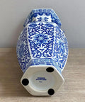 Blue and white hexagonal ceramic vase with intricate floral patterns on wooden surface