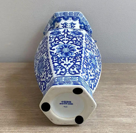 Decorative blue and white ceramic vase with intricate floral patterns on a wooden surface.