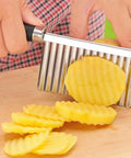 Litoexpe crinkle cutter with stainless steel blade and black handle, slicing a potato into wavy slices (kitchen tool)