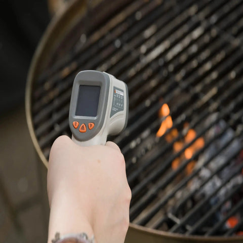 Person using No Touch Infrared Thermometer For Cooking And BBQ Laser Temperature Gun With Digital Display on grill