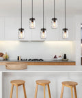 Five Light Mason Jar Chandelier with Rustic Glass Shades for kitchen island in a modern kitchen setting with wooden stools.