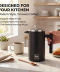 Double Wall Stainless Steel French Press Coffee Maker With Built In Thermometer And Fine Mesh Dual Filters For A Solid Morning Kick And Rich Flavor Every Time Includes Wooden Spoon For Zero Fuss Brewing In Sleek Black on kitchen counter.