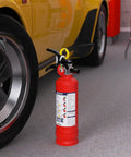 No Fuss ABC Home Fire Extinguisher 2.5 Lb Two Pack Top Shelf Rated Class A B C For Kitchen Garage next to a yellow car.