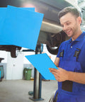 6 blue 8x8 inch non-asbestos gasket sheets, high-temperature gasket material, held by a mechanic under a car