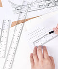 Hands using 6-inch clear plastic ruler with dual scales, part of Clear Plastic Ruler 6 Inch Plus 12 Inch set, on paper drawing.