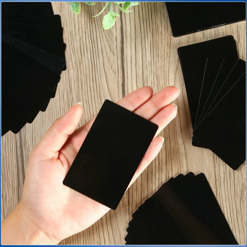 Hand holding a piece from the 300 Piece Aluminum Engraving Blanks Set For DIY Cards And Projects, 86 x 54 mm, 0.21 mm thick, black finish.