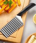 HAKIDZEL wave crinkle potato cutter with stainless steel blade and black handle on cutting board