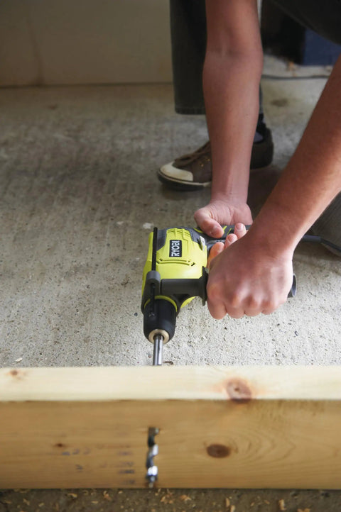 User drilling into wood with Compact Hammer Drill With Variable Speed Trigger And Reversal Built lightweight tool for home repair.