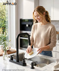 APPASO 4 Hole Kitchen Faucet Matte Black, Dual Handle with Soap Dispenser being used for washing dishes in a modern kitchen.