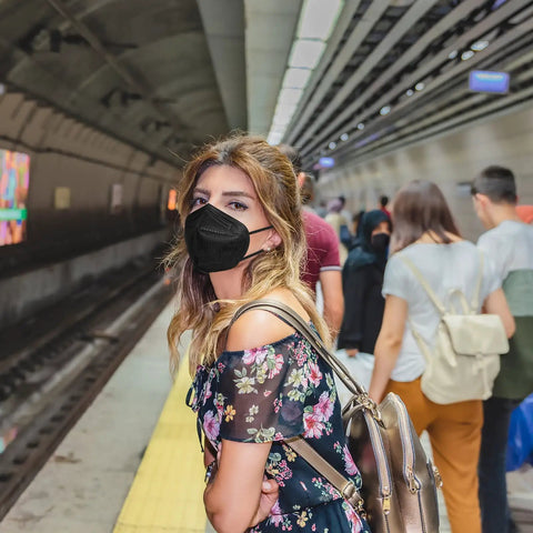 Person in subway wearing KN95 Face Mask Five Layer Cup Shaped Respirator With Breathable Comfort And High Filtration For Daily Dust And Pollutants