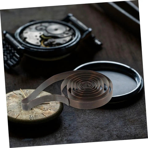 Steel Mainspring Clock Repair Kit For Mechanical Alarm Clocks 3 Pack Replacement Parts displayed with vintage clock parts