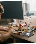 Helping Hands Soldering Tool With LED Magnifying Lamp And Adjustable Arms in use for electronics repair on a desk