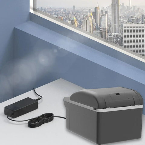 14.5 Volt Ac Dc Power Cord Kit For Portable Car Refrigerator Freezer Cooler with power adapter on a table near a window.