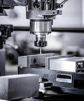 Aluminum flat bars 2x4x8 in, silver; close-up view of CNC milling machine spindle and vise.