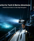 Person using Rechargeable Spotlight Flashlight With Beast Bright 42000 Candela Beam And 1400ft Range IP68 Waterproof LED Handheld Light on boat at night.