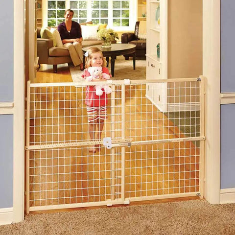 Extra Wide Wooden Baby Gate With Wire Mesh For Doorways Pressure Mounted Adjustable From About 29 To 50 Inches Wide And 31 Inches Tall Kid Safe Play Space installed in doorway with child and parent in background