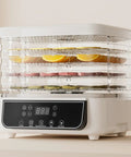 Top Shelf Five Tray Electric Food Dehydrator Featuring Killer 360 Airflow And Smart Controlled Digital Timer To Nail Fresh Fruit Veggies Meat And Healthy Homemade Snacks Daily with sliced fruits on trays.