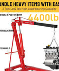 Badass 2 Ton Hydraulic Engine Hoist 4000 Lb Capacity Folding Cherry Picker with adjustable boom and 8H hydraulic pump lifting an engine.