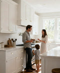 Family gathered in a bright kitchen with Straight Up Quality Brushed Gold Cabinet Knobs 6 Pack on the white cabinetry.