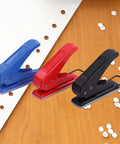 Go-To One Quarter Inch Single Hole Puncher With 20-Sheet Capacity in blue, red, black for school and office on wooden surface with punched holes