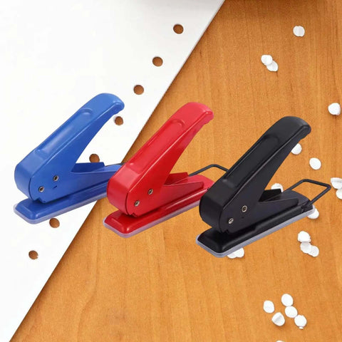 Three metal paper punches in blue, red, and black on a wooden surface, showing 1/4 inch holes and confetti, One Quarter Inch Hole Puncher With 20 Sheets Capacity Ergonomic Grip Easy Handheld Metal Paper Punch For School Office Supplies Pro Grade Go To Manual Tool For Card Making Scrapbooking Photo Albums And Crafting Projects.