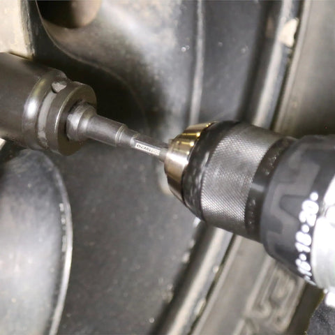 Close-up of Beefy Five Piece Impact Driver Bit Set With Hex Socket Adapters And Six Inch Drill Extension in action on a wheel