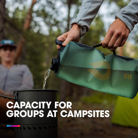 Seeker Collapsible Water Storage Bag For Camping 2L pouring water into a pot at a campsite, Mammoth Grey color.