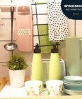 NACOLUS pink mandoline slicer with peeler, hanging on a kitchen rack