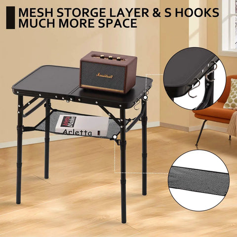 Foldable Picnic Table With Storage Net In Matte Black Aluminum Portable And Light For Camping Travel Or Indoor Use 23.6 By 15.8 Inches Three Height Settings Up To 27.5 Inches Fast Pack And Roll with items on top and mesh storage visible.
