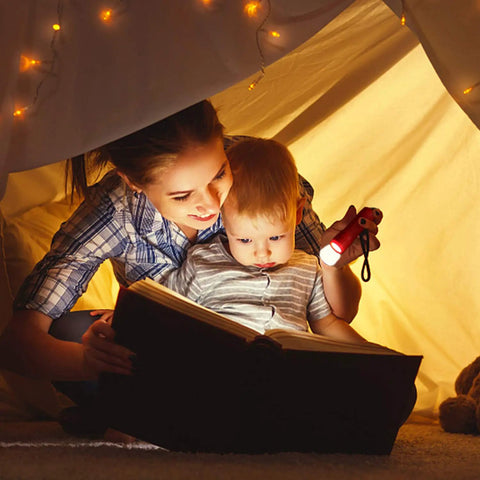 Child and parent reading a book using 30 Pack Mini LED Flashlights Set with 9 LED Beams, 90 AAA Batteries Included, indoors