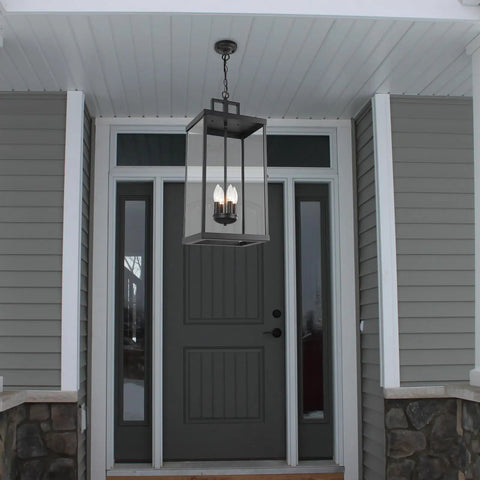 Large Twenty Five Inch Outdoor Pendant Light With Clear Glass And Sturdy Metal Build hanging at an entryway door.