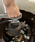 MUTUACTOR magnetic pickup tool with release handle, gray; front view lifting a metal piece from a bin.