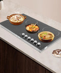 Quick Cookin' Electric Ceramic Cooktop With Five Adjustable Burners Infrared Stove Top with dishes on display and knobs visible.