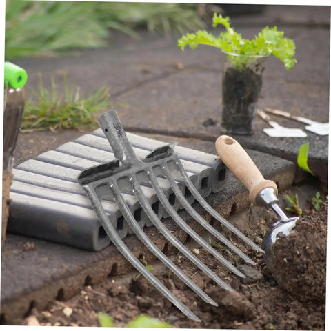 Heavy Duty Steel Fork Head For Soil Turning And Loosening with easy mount handle next to a garden trowel on soil.