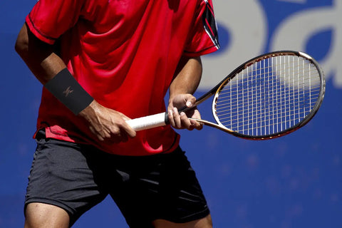 Man playing tennis wearing copper infused compression wrist sleeve for men and women boost circulation and recovery.