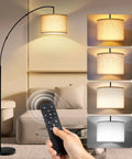 Lit Tall Arc Floor Lamp With Remote Control 81 Inch Tall Dimmable LED Stepless Color Temperature Remote Dimmer Adjustable Hanging Drum Beige Shade Modern Floor Lamp For Living Room And Bedroom with beige shade next to a beige sofa and remote control in use