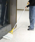 Person using a mop near a window with a 35 Quart Commercial Mop Bucket With Side Press Wringer On Wheels Included Industrial Mop Yellow For Heavy Duty Floor Cleaning And Mopping With Durable 50K Cycles Wringer And Rectangular Design in the background.