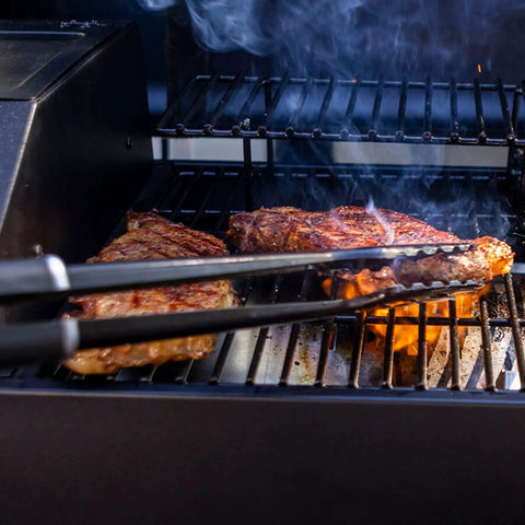 Table Top Wood Pellet Grill With Flame Broiler For Direct Searing Up To 1000°F, 7 lb hopper, grilling steaks on cast iron grates.