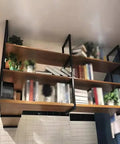 Industrial Wrought Iron Three Tier Floating Shelf Brackets Built Like A Tank For Ceiling And Wall Mount showcasing books and plants.